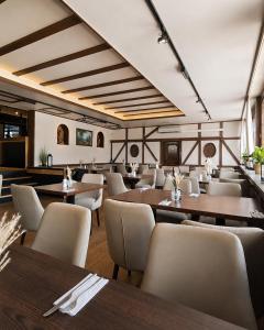 a restaurant with wooden tables and white chairs at Hotel Weinhaus Wiedemann in Ginsheim