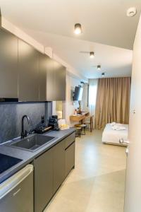 a kitchen with a sink and a bed in a room at Filian Apartments in Neos Marmaras