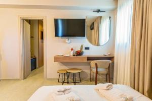 a hotel room with a bed and a desk and a mirror at Filian Apartments in Neos Marmaras