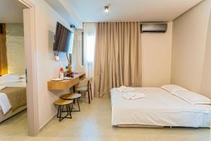 a hotel room with a bed and a desk at Filian Apartments in Neos Marmaras