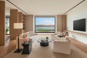 a living room with white furniture and a large window at The Dali EDITION in Dali