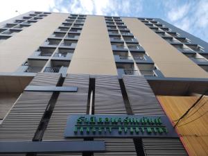 a tall building with a sign in front of it at Rangsit Apartment I in Ban Talat Rangsit