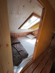 a small bed in a tiny house with a window at Camping Kerlaudy La pause Atypi'k in Plouénan