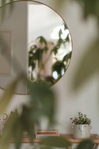 a mirror sitting on top of a table with a plant at Apartment Søglas in Gmund am Tegernsee