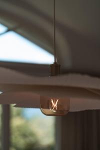 a light fixture with a fire in it in front of a window at Apartment Søglas in Gmund am Tegernsee