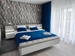 a bedroom with a large bed with blue sheets and a wall at Подих Карпат in Slavske +57 photos