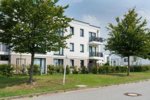 an apartment building with trees in front of it at RegioStyle Gemütliche Wohnung im Schaalseepark! in Zarrentin