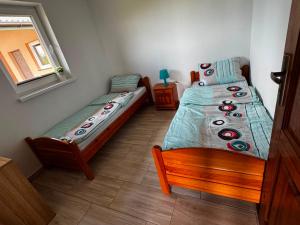 a bedroom with two twin beds and a window at Domkiuweroniki in Mielenko