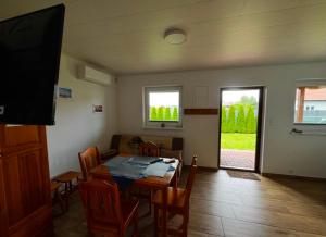 a dining room with a table and chairs and a television at Domkiuweroniki in Mielenko +13 photos