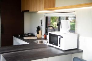 a microwave sitting on top of a kitchen counter at The Lorikeet Tiny Home with Stunning Views in Canoelands