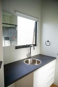 a kitchen counter with a sink and a window at The Lorikeet Tiny Home with Stunning Views in Canoelands