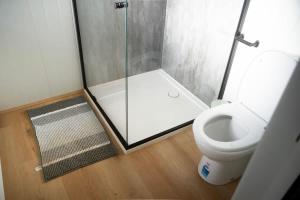 a bathroom with a glass shower and a toilet at The Lorikeet Tiny Home with Stunning Views in Canoelands