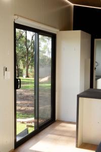 a room with a sliding glass door to a yard at The Lorikeet Tiny Home with Stunning Views in Canoelands +15 photos
