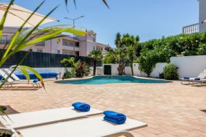 a swimming pool with two lounge chairs in a courtyard at Luz Sun Poolhouse in Luz