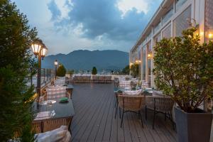 a restaurant with tables and chairs on a balcony at Ginger Rishikesh, Dehradun Road in Rishīkesh