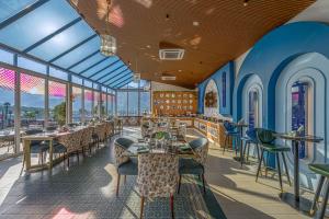 a restaurant with tables and chairs and windows at Ginger Rishikesh, Dehradun Road in Rishīkesh