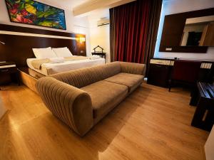 a hotel room with a couch and a bed at Mola INN Uşak in Uşak