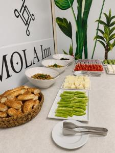 a table topped with appetizers and food on plates at Mola INN Uşak in Uşak