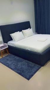 a bed with a blue headboard and a blue rug at The Abode in Lekki Phase 1