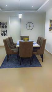 a dining room with a table and chairs and a clock at The Abode in Lekki Phase 1