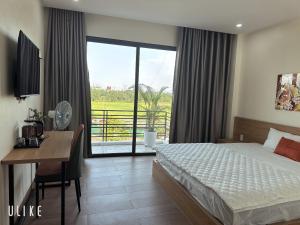 a bedroom with a bed and a desk and a window at Lala hotel in Phủ Từ Sơn