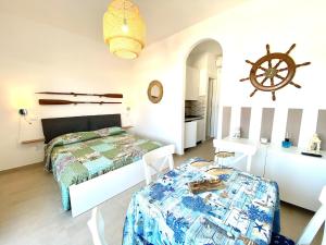 a bedroom with a bed and a table in it at Vear Hausing - Piramidi 17 in Lido delle Nazioni
