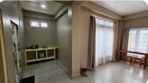 an empty living room with a window and a table at Tre Lum Homestay in Jowai