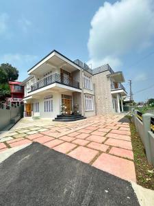 a large house with a brick driveway in front of it at Tre Lum Homestay in Jowai