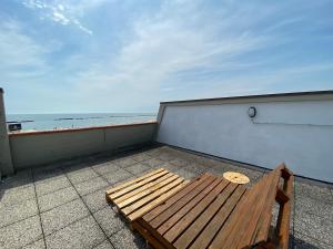 a wooden bench sitting on a balcony overlooking the ocean at Vear Hausing - Piramidi 17 in Lido delle Nazioni