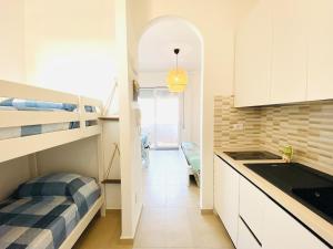 a small kitchen with a bunk bed and a hallway at Vear Hausing - Piramidi 17 in Lido delle Nazioni