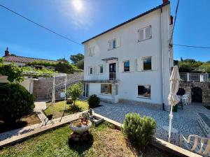 a large white house with a patio and an umbrella at Villa GoldenPearl in Povile