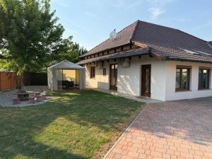 a white house with a yard with a picnic table at Tisza-tó Porta in Tiszafüred