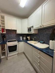 a kitchen with white cabinets and a sink at Seabreeze T3 in Carvoeiro