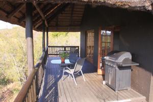a porch of a house with a table and a grill at Kunkura Game Lodge & Conference Centre in Modimolle