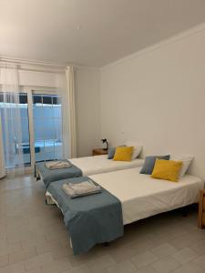 a bedroom with two beds with yellow and blue pillows at Seabreeze T3 in Carvoeiro