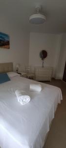 a bedroom with a white bed with a towel on it at Complejo Vallsun in Estepona +35 photos