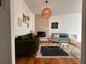 a living room with a couch and a table at Cosy Néroli - T3 - Parking privée plein centre ville in Pau