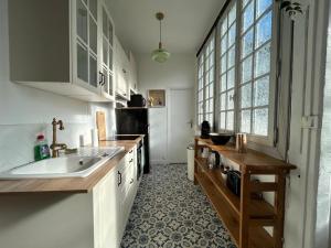 a kitchen with a sink and a counter top at Cosy Néroli - T3 - Parking privée plein centre ville in Pau +5 photos