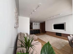 a living room with a couch and a tv at Vila apartment, free parking in Cascais