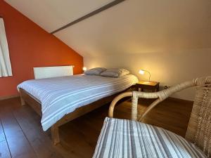 a bedroom with two beds with orange walls at Le Fournil d Andrimont in Stoumont
