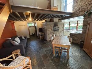 a living room with a table and a fireplace at Le Fournil d Andrimont in Stoumont