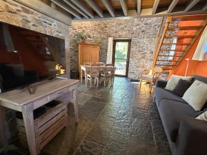 a living room with a tv and a couch and a table at Le Fournil d Andrimont in Stoumont