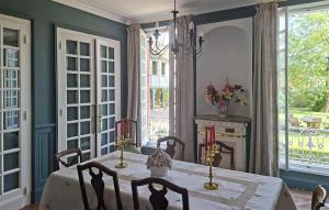 a dining room with a table and chairs and windows at Lovely Home In Clef Vallée D'eure in La Croix-Saint-Leufroy
