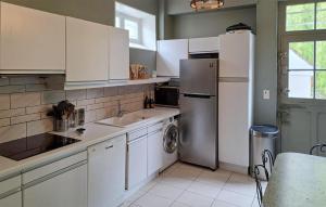 a kitchen with white cabinets and a stainless steel refrigerator at Lovely Home In Clef Vallée D'eure in La Croix-Saint-Leufroy