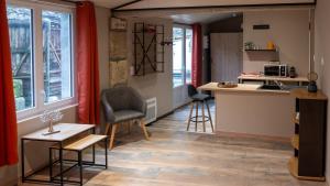a small kitchen and living room with a table and chairs at La Salamandre Enchantée in Louzac - Saint-André