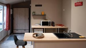 a kitchen with a sink and a microwave at La Salamandre Enchantée in Louzac - Saint-André +6 photos