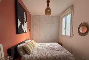 a bedroom with a bed and a window and a mirror at Cosy Néroli - T3 - Parking privée plein centre ville in Pau