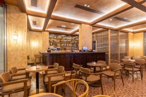 a restaurant with tables and chairs and a bar at Vatër Hotel in Shkodër