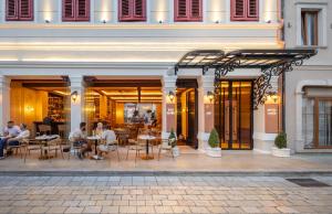 a group of people sitting at tables in a restaurant at Vatër Hotel in Shkodër