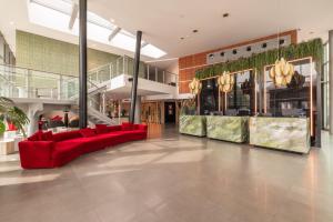 a lobby with a red couch in the middle at Savhotel Mantegna Padova in Padova